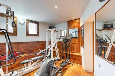 a gym with wood paneling and a treadmill at Villa TIANA Bansko 7-Bedroom Luxury Chalet in Bansko