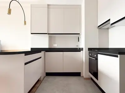a kitchen with white cabinets and black appliances at Hotel HAYASHI - Free Parking and Fitness in Sofia