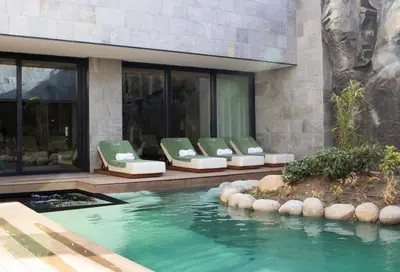 a swimming pool with green chairs next to a building at Hotel HAYASHI - Free Parking and Fitness in Sofia