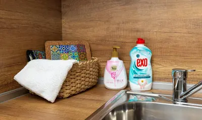 a bathroom sink with detergent and a basket of towels at City Retreat with Local Charm in Plovdiv