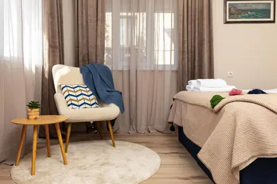 a bedroom with a bed and a chair and a table at City Retreat with Local Charm in Plovdiv