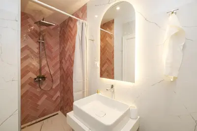 a white bathroom with a sink and a mirror at The House of Pom in Plovdiv
