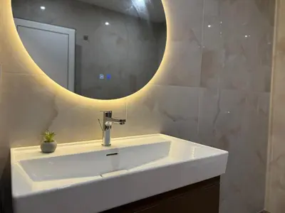 a bathroom with a sink and a mirror at SkyWay by NightSpace- Modern City Apartment in Sofia