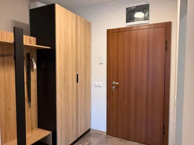 a closet with a wooden door in a room at SkyWay by NightSpace- Modern City Apartment in Sofia