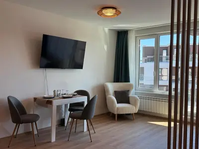 a room with a table and chairs and a window at SkyWay by NightSpace- Modern City Apartment in Sofia