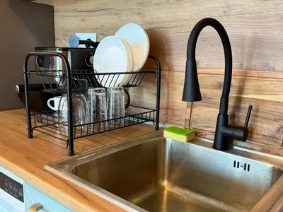 a kitchen sink with a dish drying rack next to it at SkyWay by NightSpace- Modern City Apartment in Sofia