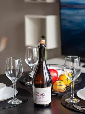 a bottle of wine sitting on a table with glasses at Modern Vitosha View Apartment with Free Parking in Sofia