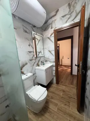 a bathroom with a white toilet and a sink at Комплекс Ванката in Kamena