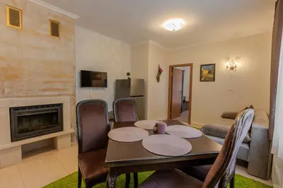 a dining room with a table and a fireplace at 2R Ski - ТуЕр Ски in Smolyan