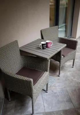 two coffee cups on a table with two chairs at Top Central Apartment 14 in Sofia