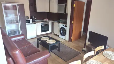 a living room with a couch and a kitchen at Borovets Apartments, Flora Violet Residence in Borovets