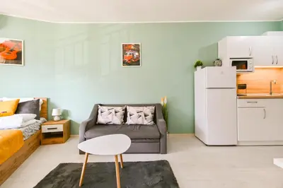 a living room with a couch and a white refrigerator at Armand de Sanelle in Sofia