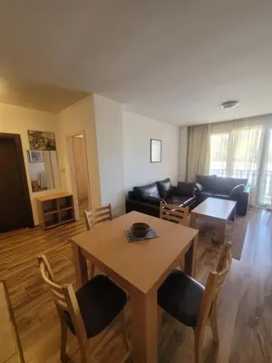 a living room with a table and a couch at Ramada2 Alexander Services Apartments in Bansko