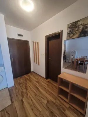 a living room with a wooden floor and a door at Ramada2 Alexander Services Apartments in Bansko