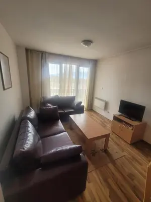 a living room with a leather couch and a coffee table at Ramada2 Alexander Services Apartments in Bansko