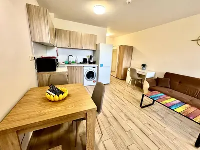 a kitchen and living room with a table and a couch at Joyful Studio in Sofia