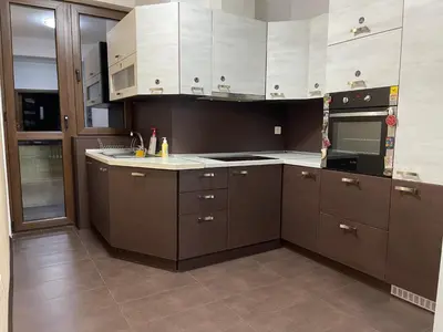 a kitchen with brown cabinets and white appliances at Cinema house at Sofia center in Sofia