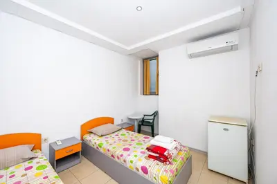 a small bedroom with two beds and a desk at Lifto Hostel in Voyvodinovo