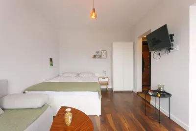 a bedroom with two beds and a television in it at Serdica Tower View DT Parking Wi-Fi AC in Sofia