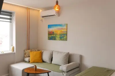 a living room with a couch and a table at Serdica Tower View DT Parking Wi-Fi AC in Sofia
