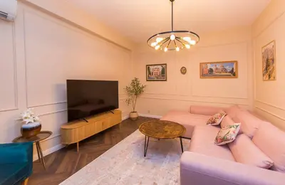 a living room with a couch and a flat screen tv at The Pearl Downtown in Sofia