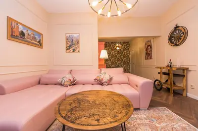 a living room with a pink couch and a table at The Pearl Downtown in Sofia