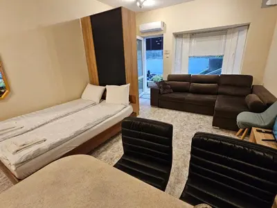 a living room with a bed and a couch at Bright and Cozy Studio with Garage near the Center in Sofia
