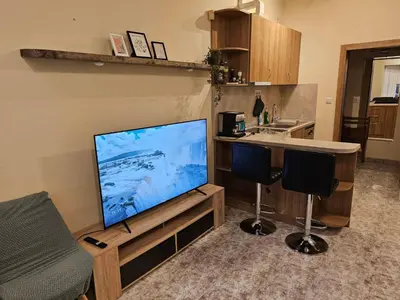 a living room with a large flat screen tv in a kitchen at Bright and Cozy Studio with Garage near the Center in Sofia