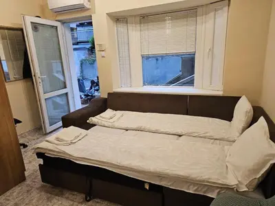 a bed sitting in a room with a window at Bright and Cozy Studio with Garage near the Center in Sofia