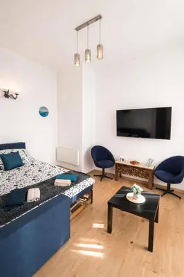 a room with a bed and two chairs and a table at Stylish apartment, top center with private Sauna! in Sofia