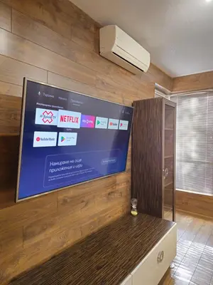 a flat screen tv on a wall in a room at Two Big Bed Apartment & FREE Underground Parking in Sofia