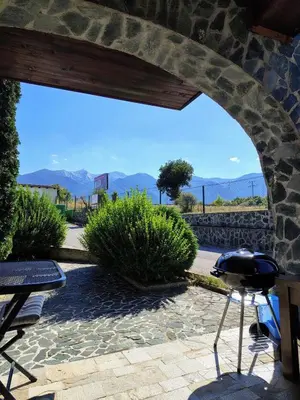 a patio with a grill and mountains in the background at Fairytale Cottage in Redenka in Razlog