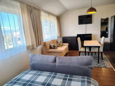 a living room with a couch and a table at Bansko Tower Cozy Studio with Mountain View in Bansko