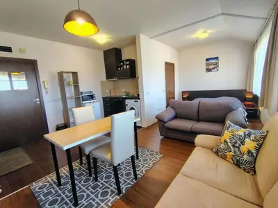 a living room with a table and a couch at Bansko Tower Cozy Studio with Mountain View in Bansko