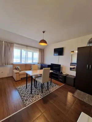 a living room with a table and a couch at Bansko Tower Cozy Studio with Mountain View in Bansko