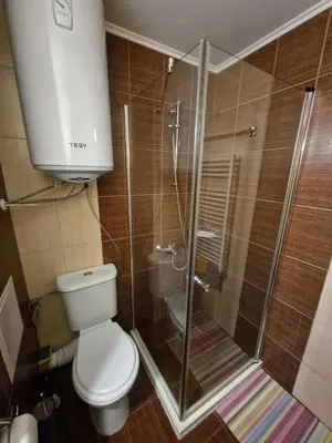 a bathroom with a toilet and a glass shower at Bansko Tower Cozy Studio with Mountain View in Bansko