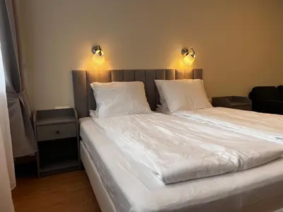 a large white bed with two pillows and two lights at TwinStay #6 - Deluxe Super King Suite in Sofia
