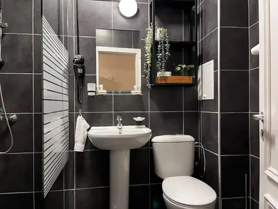 a bathroom with a white toilet and a sink at TwinStay #6 - Deluxe Super King Suite in Sofia