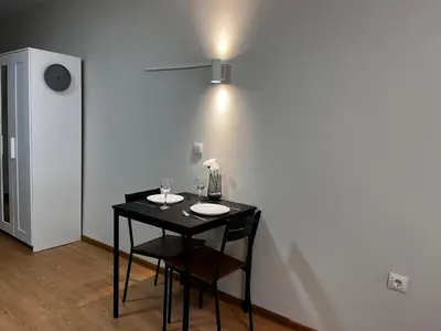 a black table with two chairs and a light on a wall at TwinStay #6 - Deluxe Super King Suite in Sofia