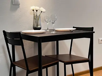 a black table with two chairs and a vase with flowers at TwinStay #6 - Deluxe Super King Suite in Sofia