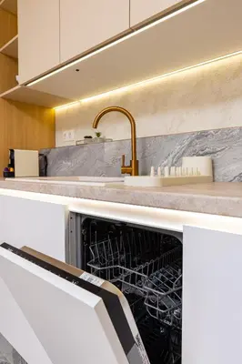 an open dishwasher in a kitchen with a sink at Stylish City Escape 1BD Apartment in Plovdiv in Plovdiv