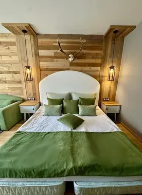 a bedroom with a large bed with green sheets at Hotel Borovets Palace in Borovets