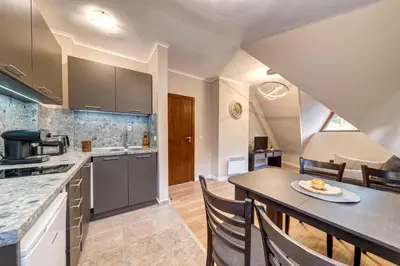 a kitchen with a table and chairs in a room at Top floor Ski-In Stay in Pamporovo