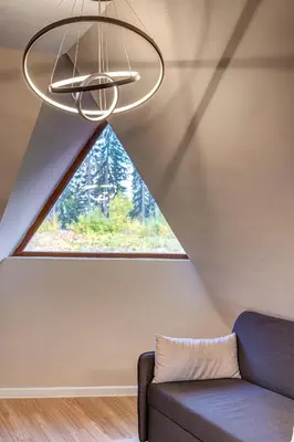 a room with a couch and a large window at Top floor Ski-In Stay in Pamporovo