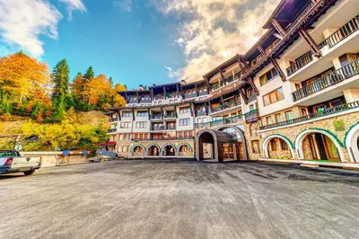 an empty parking lot in front of a large building at Ski Slope Getaway at Grand Monastery in Pamporovo