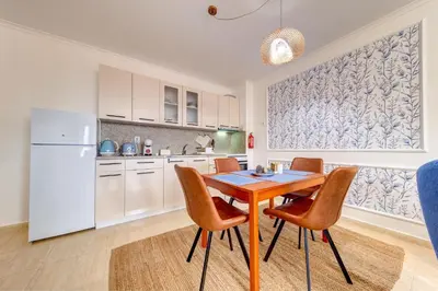 a kitchen with a table and chairs and a refrigerator at Ski Slope Getaway at Grand Monastery in Pamporovo