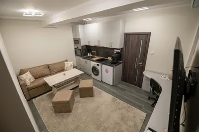 a small living room with a couch and a kitchen at Апартамент Милена in Smolyan
