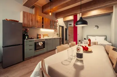 a kitchen and a dining room with a table and chairs at Rila Zen Apartment in Samokov