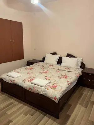 a bedroom with a bed with a floral blanket at Country House БатЖоро
