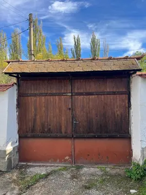 a large wooden garage door with a rusty roof at Country House БатЖоро